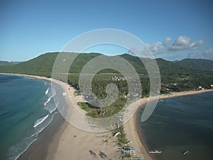 A scenic Hyperlapse Drone view of El Nido Nacpan palm tree Twin Beach Palawan Philippines by the mountains under a blue