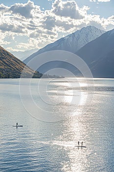 scenic lake view with paddleboarders enjoying the calm waters. healthy lifestyle photo