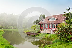 The scenic landscape. brick house by Lake. Reflection in water.