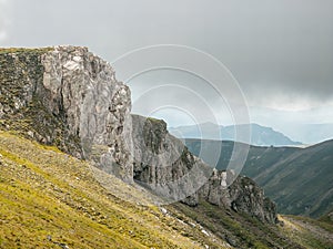 Scenic landscape in Bucegi Mountains with a huge rock formation against a dark cloudy sky