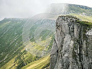 Scenic landscape in Bucegi Mountains with a huge rock formation against a dark cloudy sky