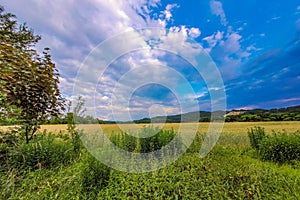 Scenic landscape featuring a green field with hills in the distance. Plavno, Banska Bystrica.