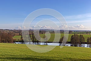 Scenic landscape with fields and river early spring