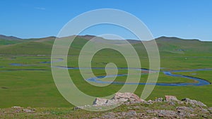 Scenic landscape of green fields with swirling rivers during daytime