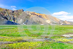 Scenic landscape in Iceland with mountains, green meadows and water of the river. Landmannalaugar, Fjallabak Nature Reserve.