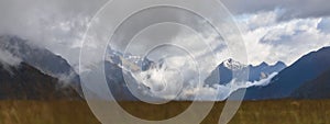 Scenic landscape of rocky mountains covered in a blanket of fluffy clouds. New Zealand