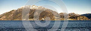 Scenic landscape of snow covered mountains near Forsand with a passenger ferry crossing Frafjord