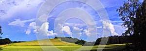 Scenic landscape with storm cloud in background over green agriculture fields