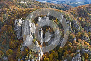 Scenic landscape in Sulov, Slovakia, on beautiful autumn sunrise with colorful leaves on trees in forest and bizarre pointy rocks