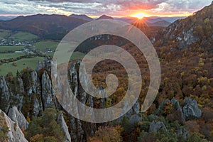 Scenic landscape in Sulov, Slovakia, on beautiful autumn sunrise with colorful leaves on trees in forest and bizarre pointy rocks