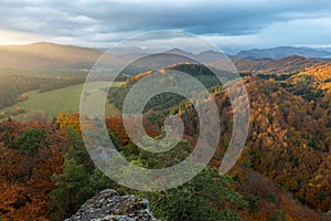 Scenic landscape in Sulov, Slovakia, on beautiful autumn sunrise with colorful leaves on trees in forest and bizarre pointy rocks