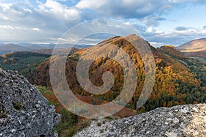 Scenic landscape in Sulov, Slovakia, on beautiful autumn sunrise with colorful leaves on trees in forest and bizarre pointy rocks