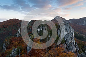 Scenic landscape in Sulov, Slovakia, on beautiful autumn sunrise with colorful leaves on trees in forest and bizarre pointy rocks