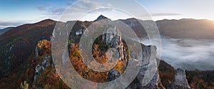 Scenic landscape in Sulov, Slovakia, on beautiful autumn sunrise with colorful leaves on trees in forest and bizarre pointy rocks