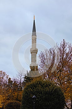 Scenic landscape view of ancient minaret against cloudy sky. Minaret of the mosque of Hagia Sophia in Sultan Ahmed Park