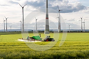 Scenic landscape view big modern tractor machine with sprayer equipment spraying fertilizer in rapeseed agricultural