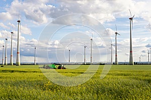 Scenic landscape view big modern tractor machine with sprayer equipment spraying fertilizer in rapeseed agricultural