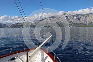Scenic landscape view of the Croatian sea coast, mountains, sky and clouds from a pleasure boat