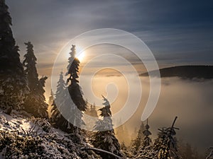 Scenic landscape with a view from a mounatin range to the valley filled with low clouds and fog during temperature inversion