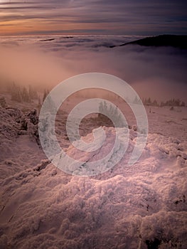 Scenic landscape with a view from a mounatin range to the valley filled with low clouds and fog during temperature inversion