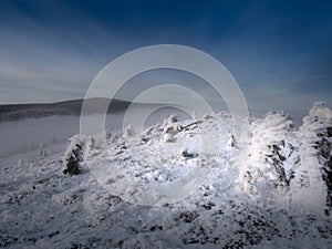 Scenic landscape with a view from a mounatin range to the valley filled with low clouds and fog during temperature inversion