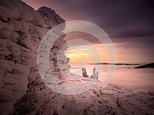 Scenic landscape with a view from a mounatin range to the valley filled with low clouds and fog during temperature inversion