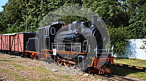 Scenic landscape view of vintage steam train locomotive type GR with old wooden freight wagon