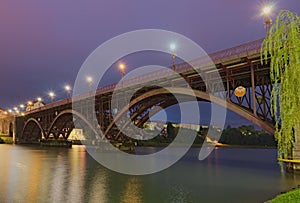 Scenic morning view of illuminated Old Bridge also named the State over Drava River. Selective focus with wide angle lens.