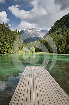Scenic mountain lake plansarsko view with wooden footbridge, slovenia