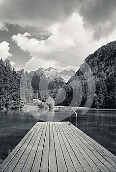 Scenic mountain lake plansarsko view with wooden footbridge, slovenia