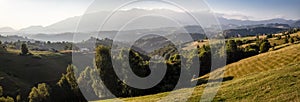 Scenic mountain panorama. Beautiful summer mountain landscape with green field and dramatic cloudy sky in Romanian Carpathian