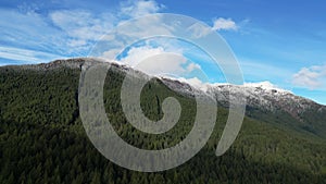 Scenic Mountain Peak with Trees and Snow. Aerial Mountain Scene. Dramatic Cloudy Sky. BC, Canada.