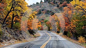 A scenic mountain road lined with colorful autumn trees leads to a secluded valley where an ancient Native American