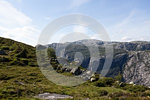 Scenic mountain valley in the countryside, featuring lush green grass, and rocky outcrops.