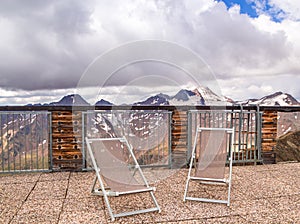 Scenic mountain view from panoramic terrace with deck chairs