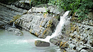 Scenic nature of a beautiful waterfall and emerald of a fresh water lake in a wild jungle forest environment. 4k, slow