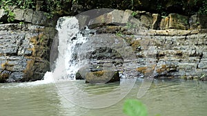 Scenic nature of a beautiful waterfall and emerald of a fresh water lake in a wild jungle forest environment. 4k, slow