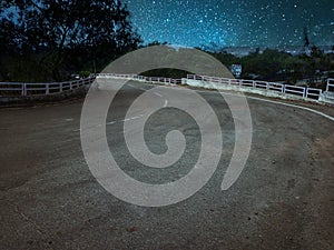 Scenic night landscape of country road at night with stars on the sky.