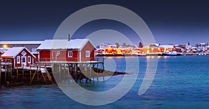 Scenic night lights of Lofoten islands, Norway, Reine and red houses in fishing village on a sea shore