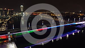 Scenic nighttime view of Belgrade Branko bridge over water, with cars seen driving across