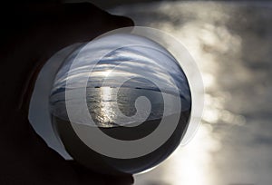 Scenic Ocean Sunset Captured in Glass Ball with Light in Sea