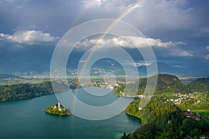 Scenic panoramic view of Lake Bled from above with double rainbow on the sky