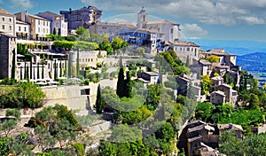 Scenic panoramic view on medieval picturesque old french village on hill top, blue summer sky, fluffy clouds - Gordes, Provence,