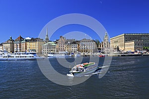 Scenic panoramic view of Stockholm`s Old Town Gamla Stan with a passenger ship sailing on the foreground