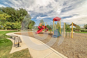 Scenic park and colorful playground under blue sky and clouds on a sunny day