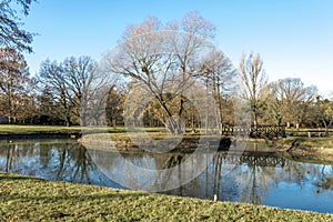 Scenic pond with trees mirrored in water in the park next to Zrinyi Castle, Szigetvar, Hungary