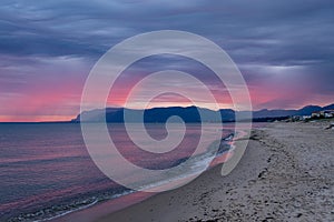 Scenic red sunrise over coastline with sandy beach and clear sea water in Alcamo Marina, small town in Sicily, Italy, summer