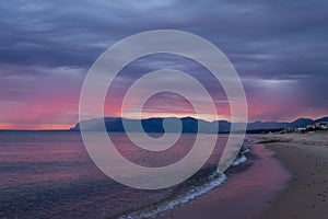 Scenic red sunrise over coastline with sandy beach and clear sea water in Alcamo Marina, small town in Sicily, Italy, summer