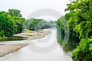 Scenic river with historic water mill and trees along banks