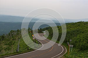 Scenic road bending through the landscapes of Akan National Park photo